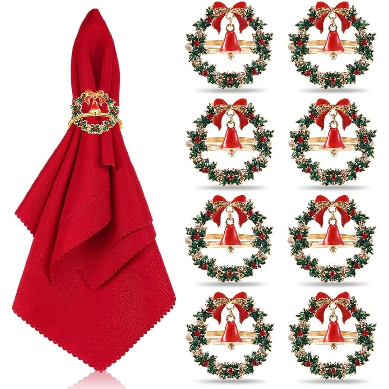 Ein roter Stoffserviette mit einem goldenen Ring neben sechs dekorativen Weihnachtstellern mit roten Glocken und Stechpalmen-Kränzen.