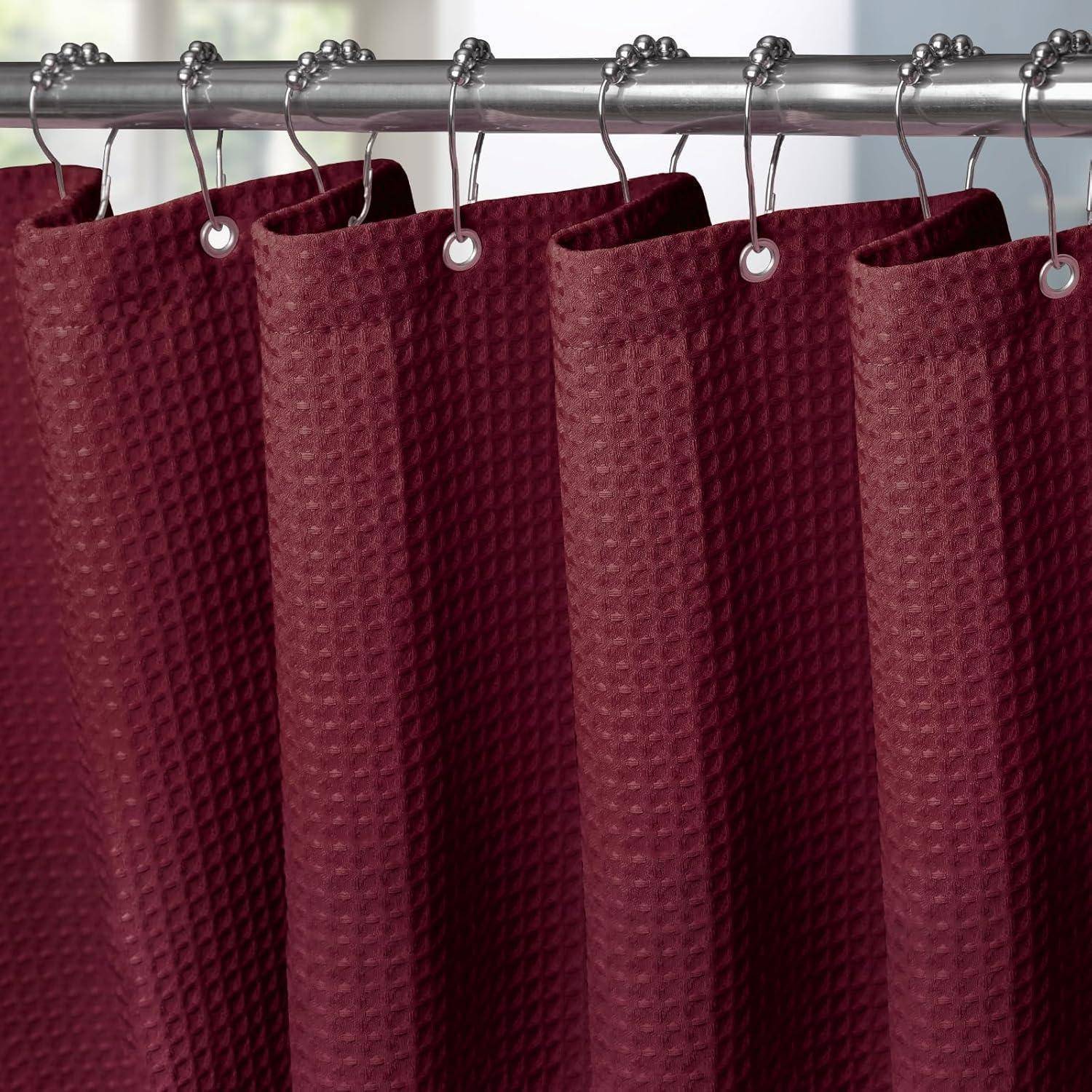 Ein roter, strukturierter Duschvorhang hängt an silbernen Haken an einer geraden Stange, wobei weiches Licht von einem Fenster im Hintergrund einfällt.