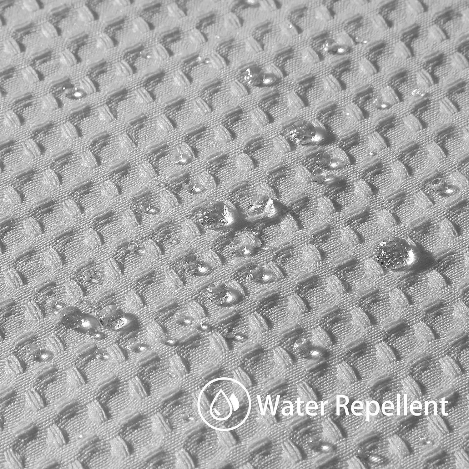 Nahaufnahme eines strukturierten Gewebes mit Wassertropfen, die sich auf der Oberfläche sammeln und die wasserabweisende Eigenschaft des Materials veranschaulichen.