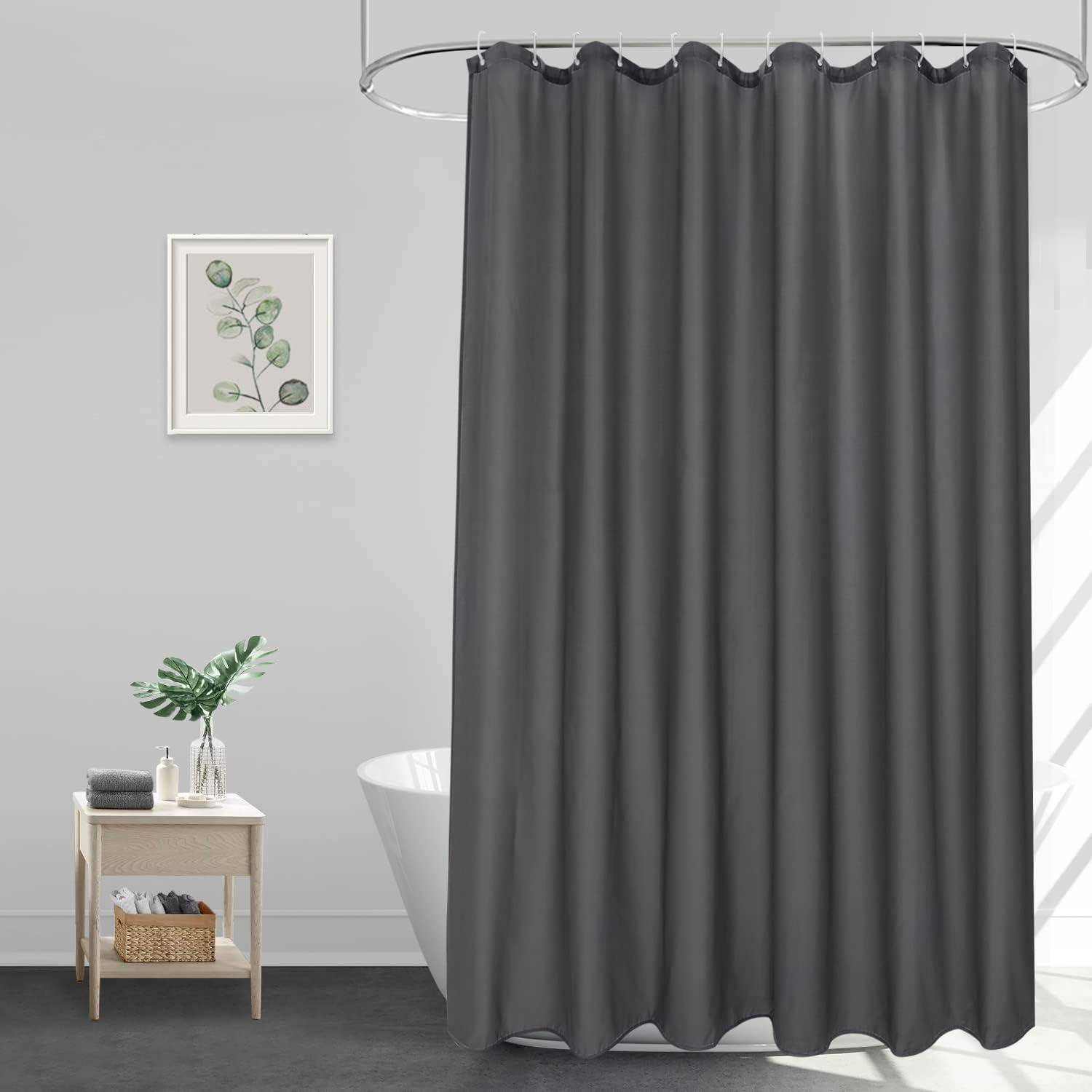 Ein Badezimmer mit einem grauen Duschvorhang, einem Holztisch mit Toilettenartikel und einer Vase sowie einem gerahmten Pflanzendruck an der Wand.