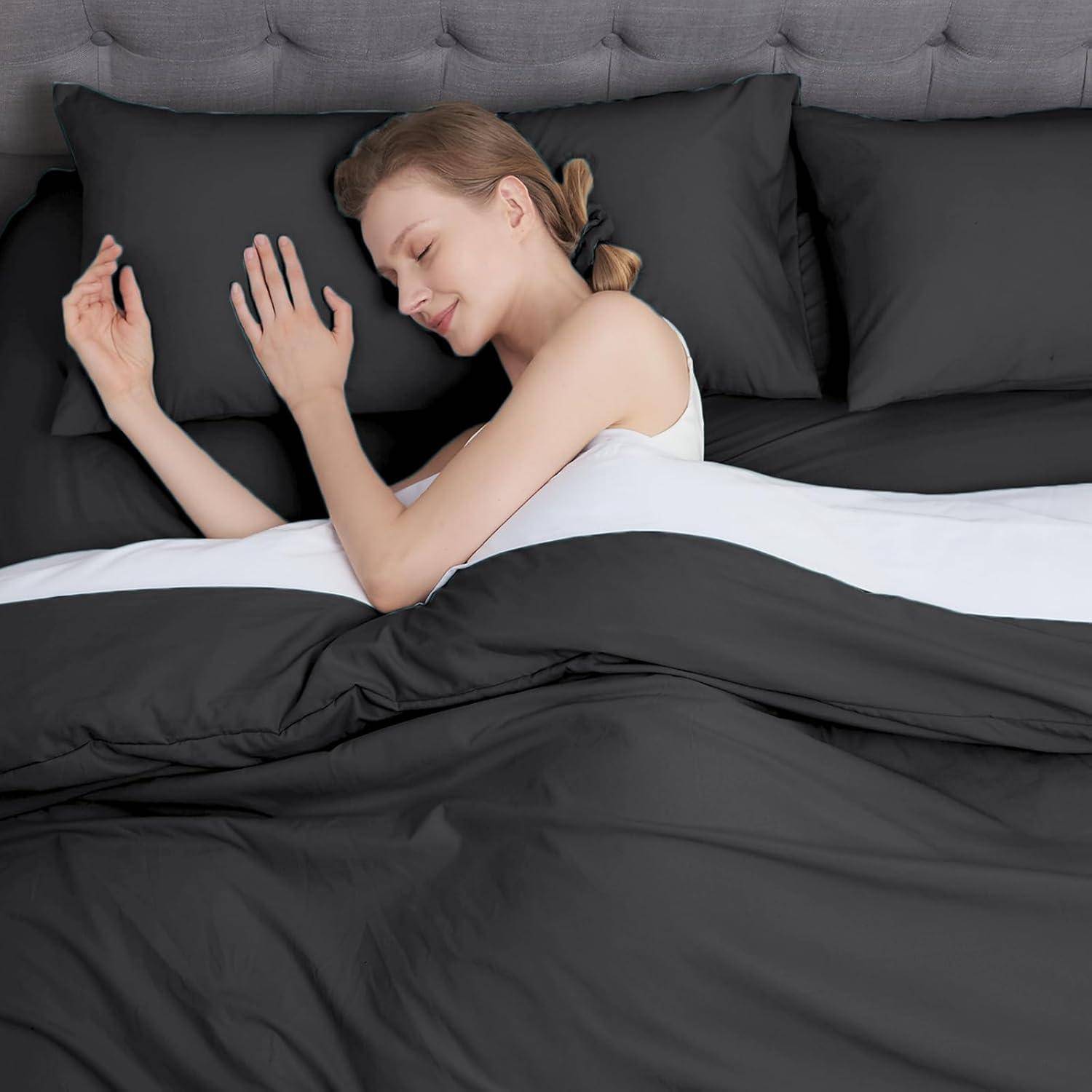 Eine Person, die friedlich auf einem Bett mit dunkelgrauer Bettwäsche schläft und ihren Kopf auf einem Kissen ruhen lässt, was eine friedliche und erholsame Umgebung zeigt.