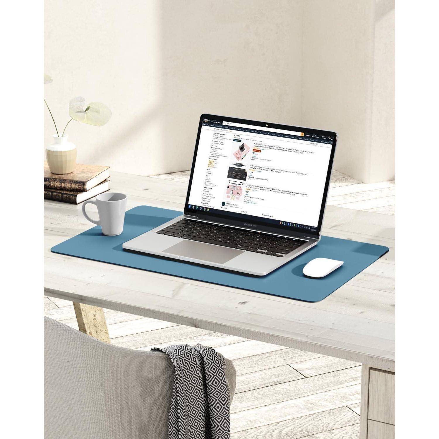 Ein Laptop auf einem Tisch zeigt eine Webseite mit einer Shopping-Website, begleitet von einer Tasse und einer Pflanze; eine Maus liegt auf einer blauen Unterlage.