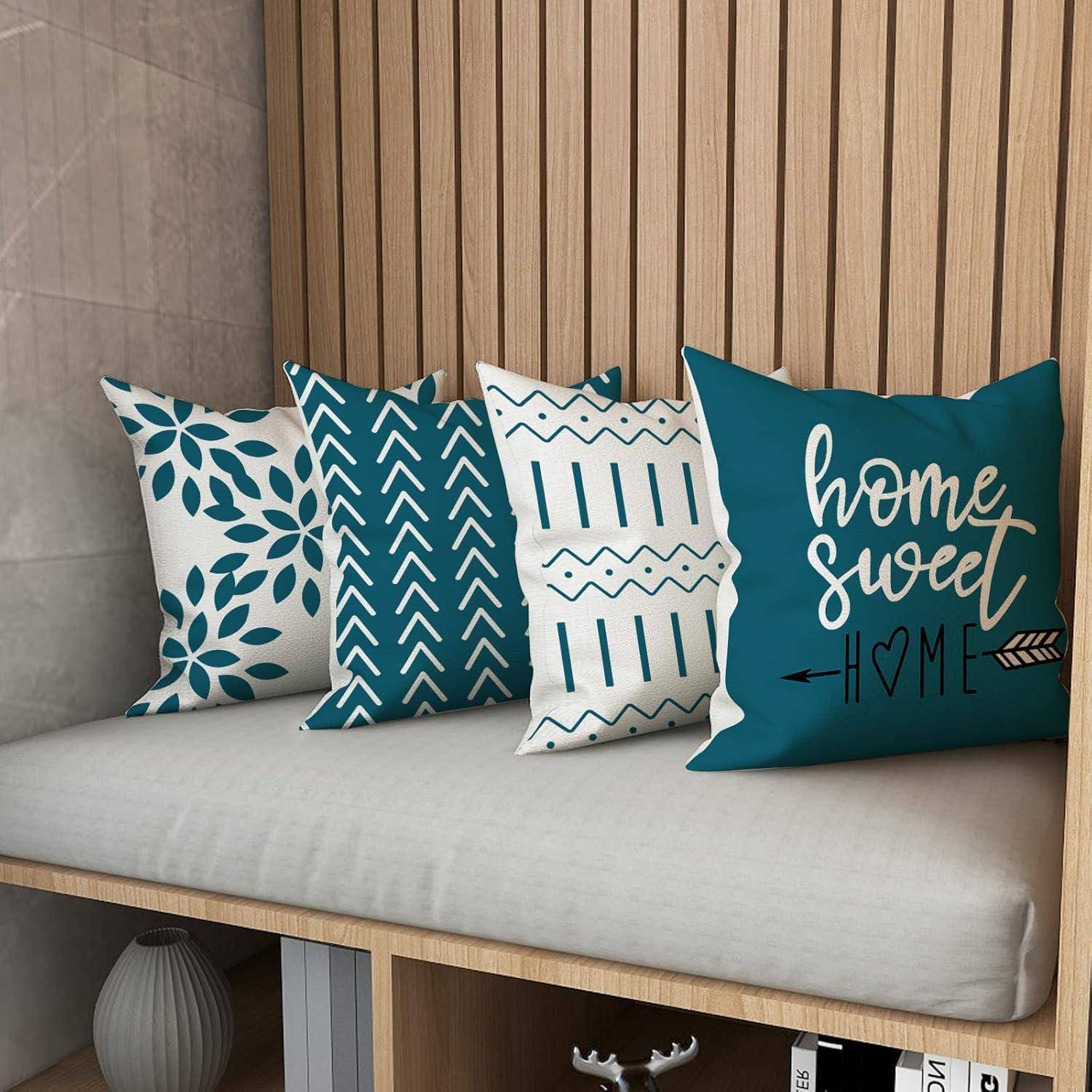 Dekorative Kissen mit blauen Mustern und dem Schriftzug 'home sweet home' auf einer Holzbank in einer gemütlichen, modernen Nischenecke.