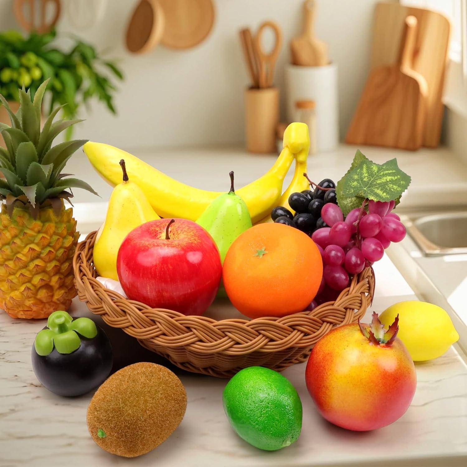 Ein Obstkorb auf der Küchenarbeitsplatte enthält Bananen, Äpfel, eine Orange und Trauben. In der Nähe werden eine Ananas, eine Limette, eine Kiwi und ein Granatapfel präsentiert.