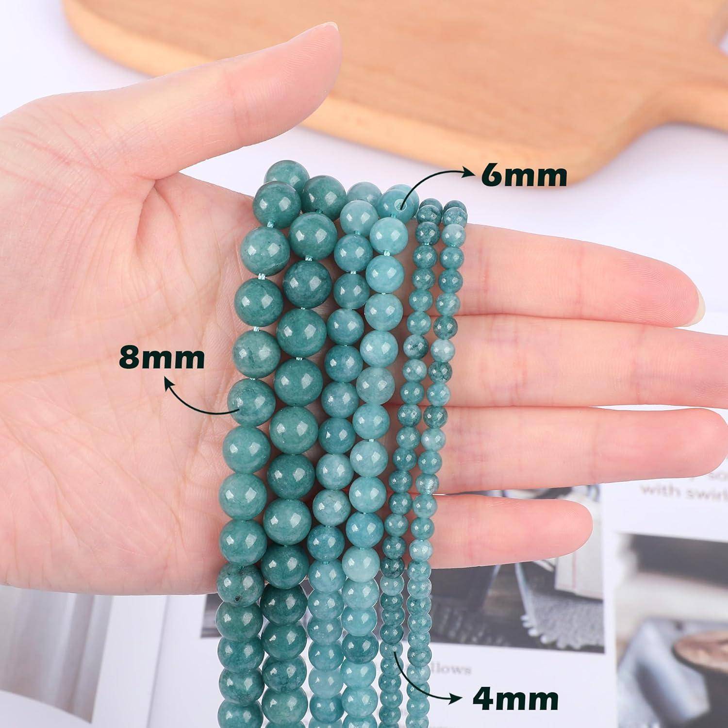 Hand, die Stränge grüner Perlen in verschiedenen Größen hält: 4 mm, 6 mm und 8 mm.