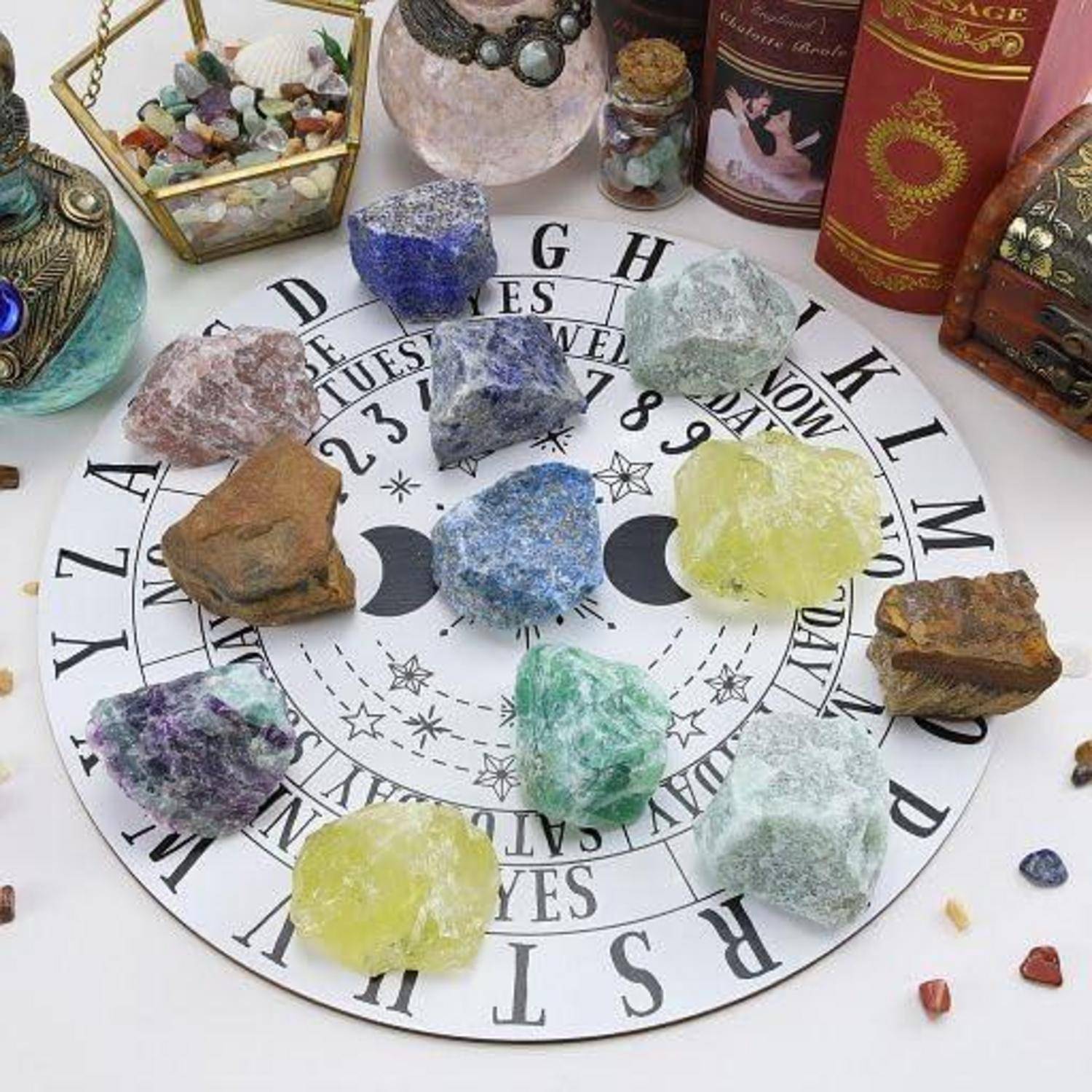 Eine runde Matte mit astrologischen Symbolen, auf der verschiedenfarbige Kristalle platziert sind, umgeben von mystischen Gegenständen wie einem Kessel.