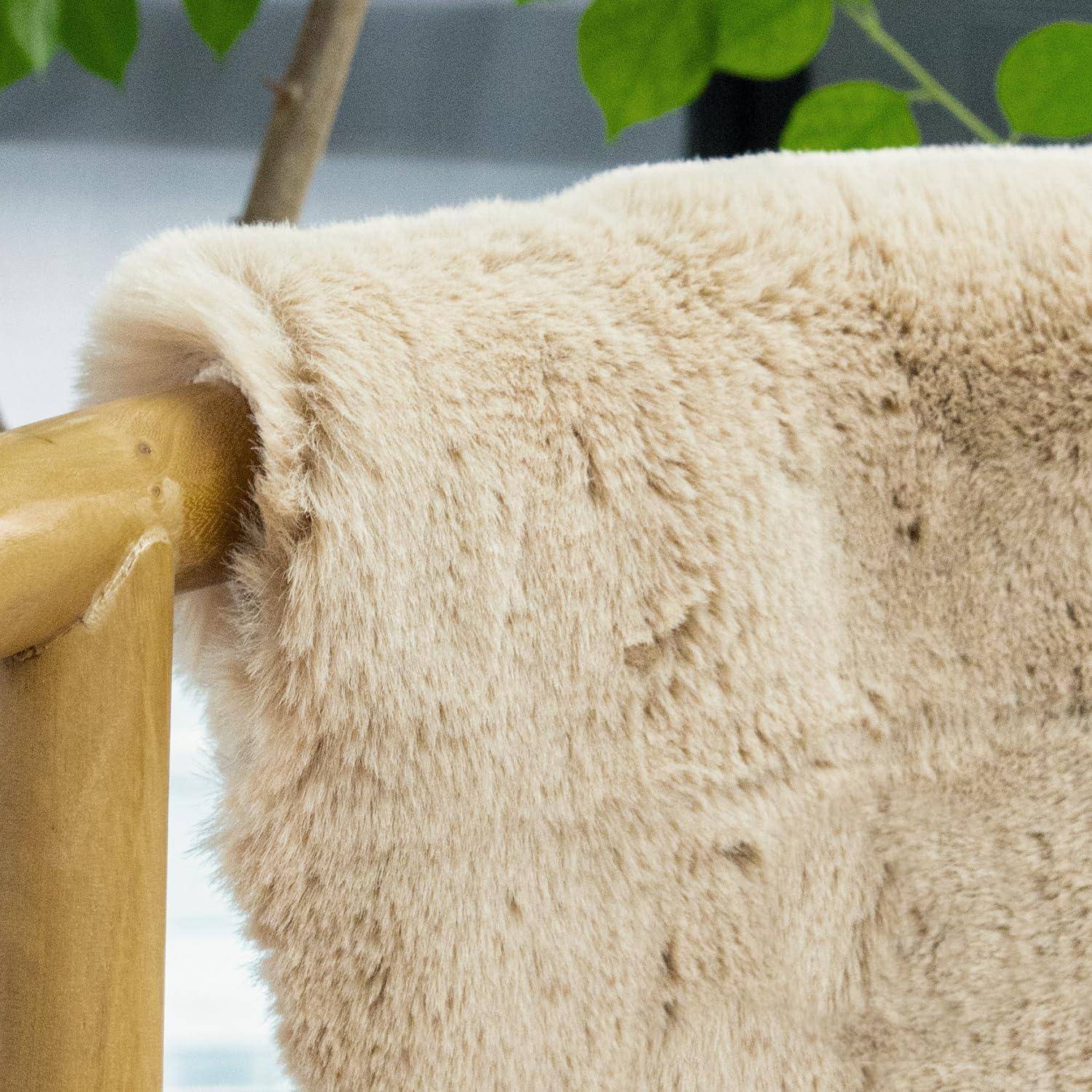 Eine weiche, beige Kunstfelldecke, die über eine Holzarmlehne gebreitet ist, mit grünen Blättern im Hintergrund, was eine gemütliche Atmosphäre andeutet.