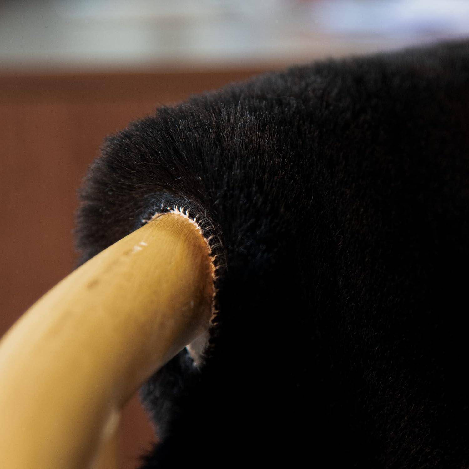 Eine Nahaufnahme einer schwarzen, pelzigen Katze, die sich um ein Stuhlbein aus Holz windet, wobei der Hintergrund weich unscharf ist und eine gemütliche Atmosphäre schafft.