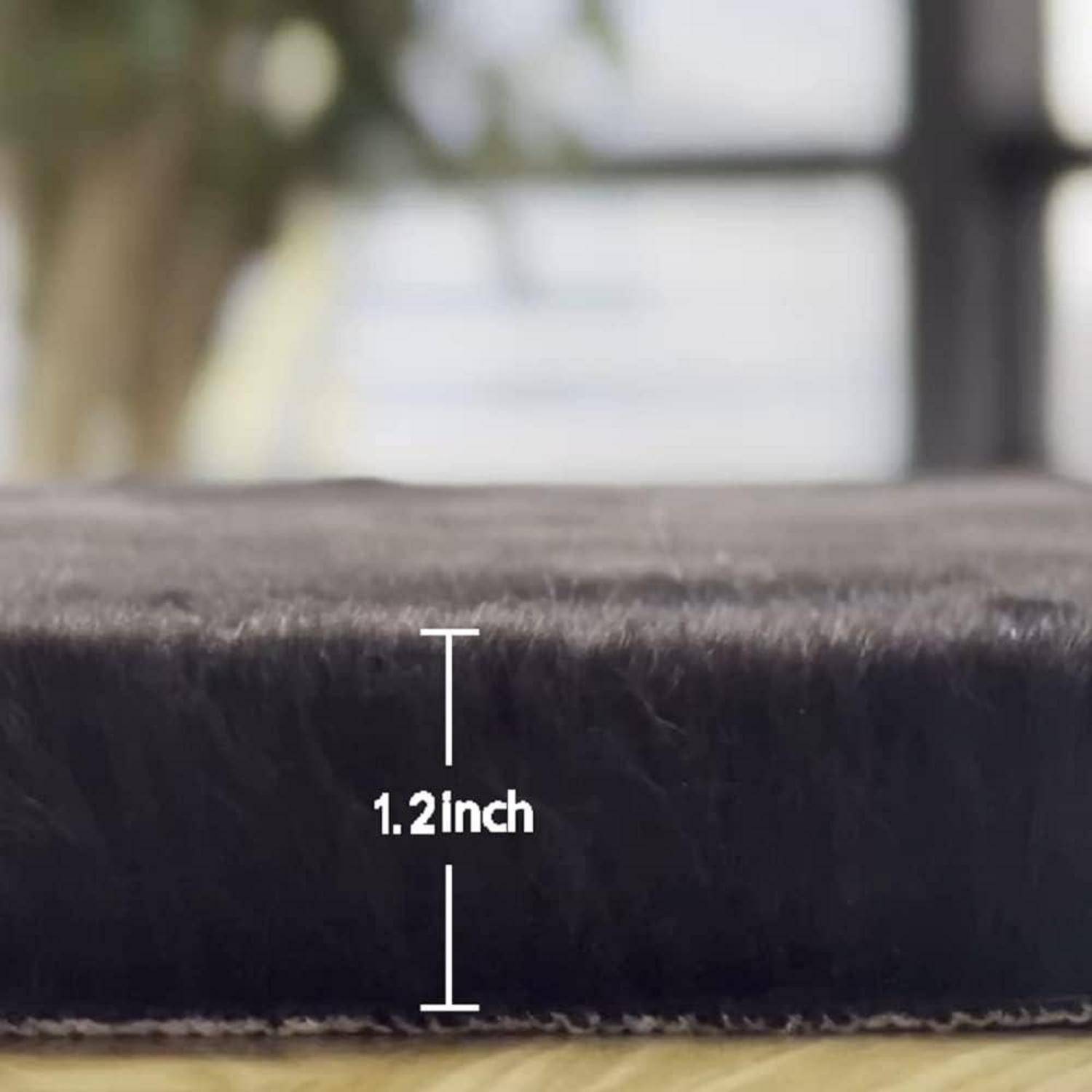 Eine Nahaufnahme eines dunklen, weichen Materials mit einer Beschriftung, die eine Dicke von '1,2 Zoll' angibt. Der Hintergrund ist unscharf und deutet auf eine Innenraum-Umgebung hin.