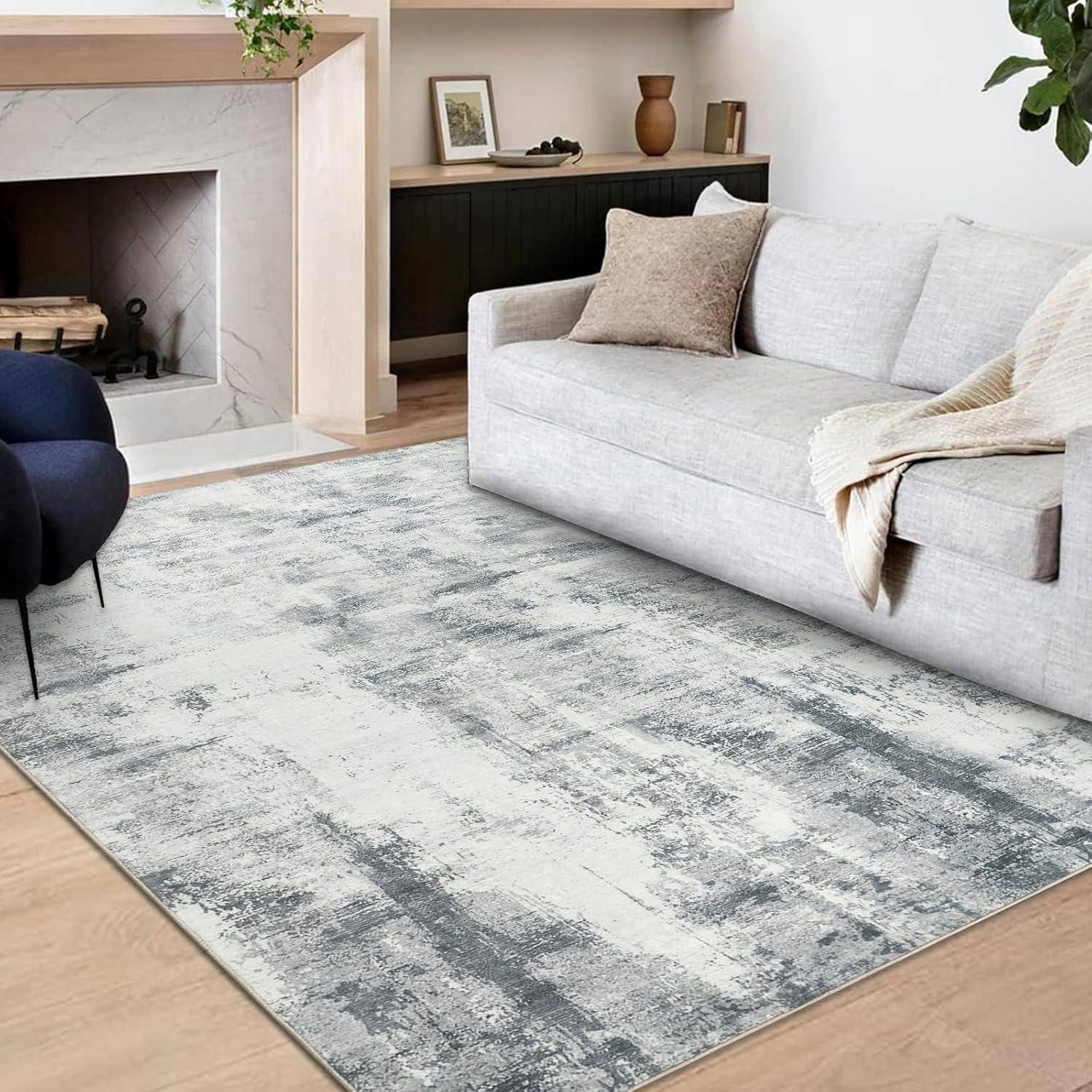 Ein modernes Wohnzimmer mit einer hellgrauen Couch, beige und braunen Kissen, einem strukturierten grauen Teppich und einem Kamin neben grünen Pflanzen.