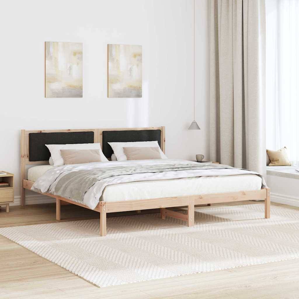 Ein modernes Schlafzimmer mit einem Holzbett, zwei Kissen und einer beigen Decke. Zwei abstrakte Gemälde hängen darüber, mit einem Nachttisch und einer Lampe in der Nähe.