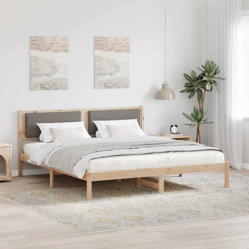 Ein modernes Schlafzimmer mit einem Holzbettrahmen, weißer Bettwäsche, zwei abstrakten Gemälden über dem Kopfende und einer Topfpflanze auf der rechten Seite.