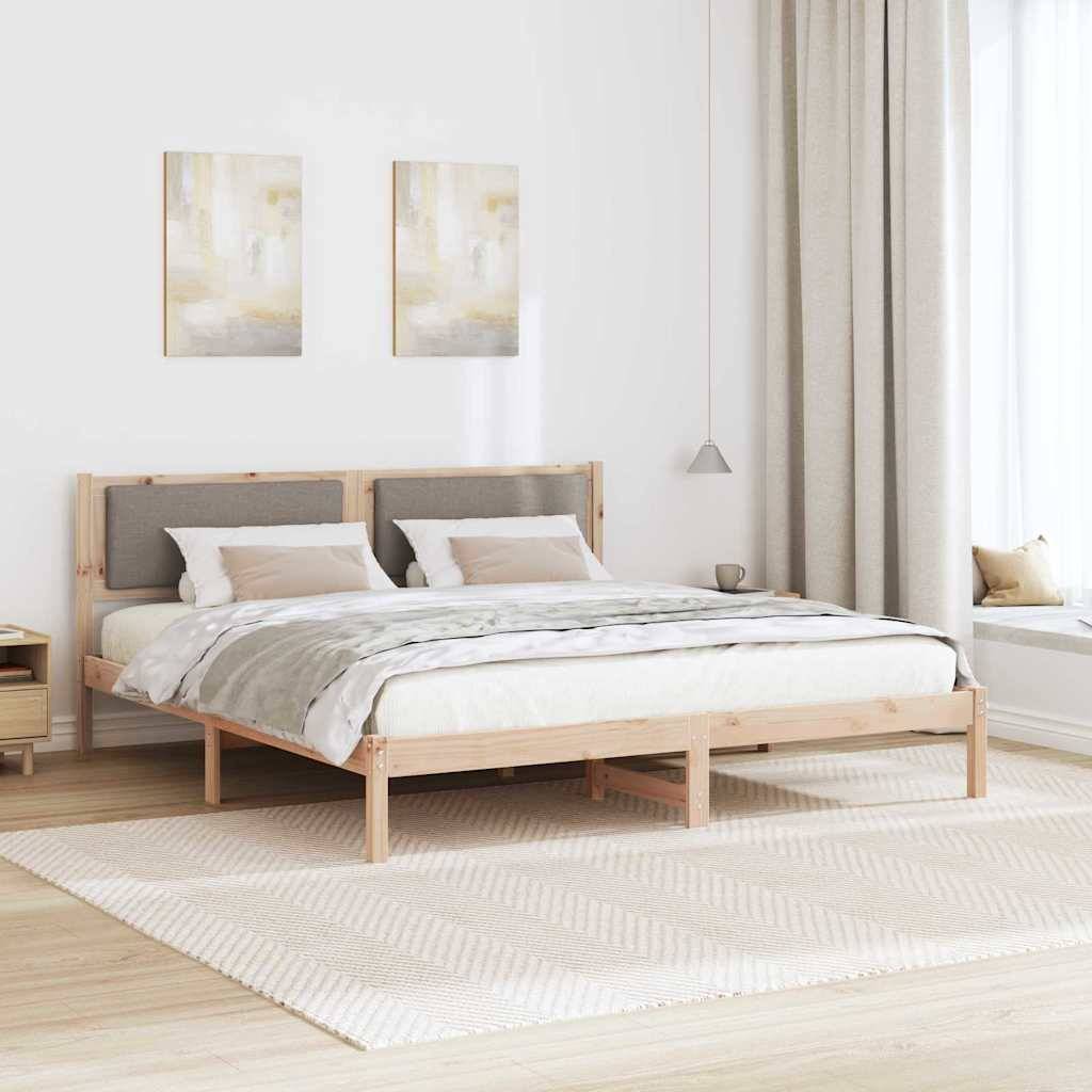 Zeitgenössisches Schlafzimmer mit einem Holzbettgestell, grauer und weißer Bettwäsche, hellem Holzboden und minimalem Dekor, einschließlich Wandkunst und einer Lampe.