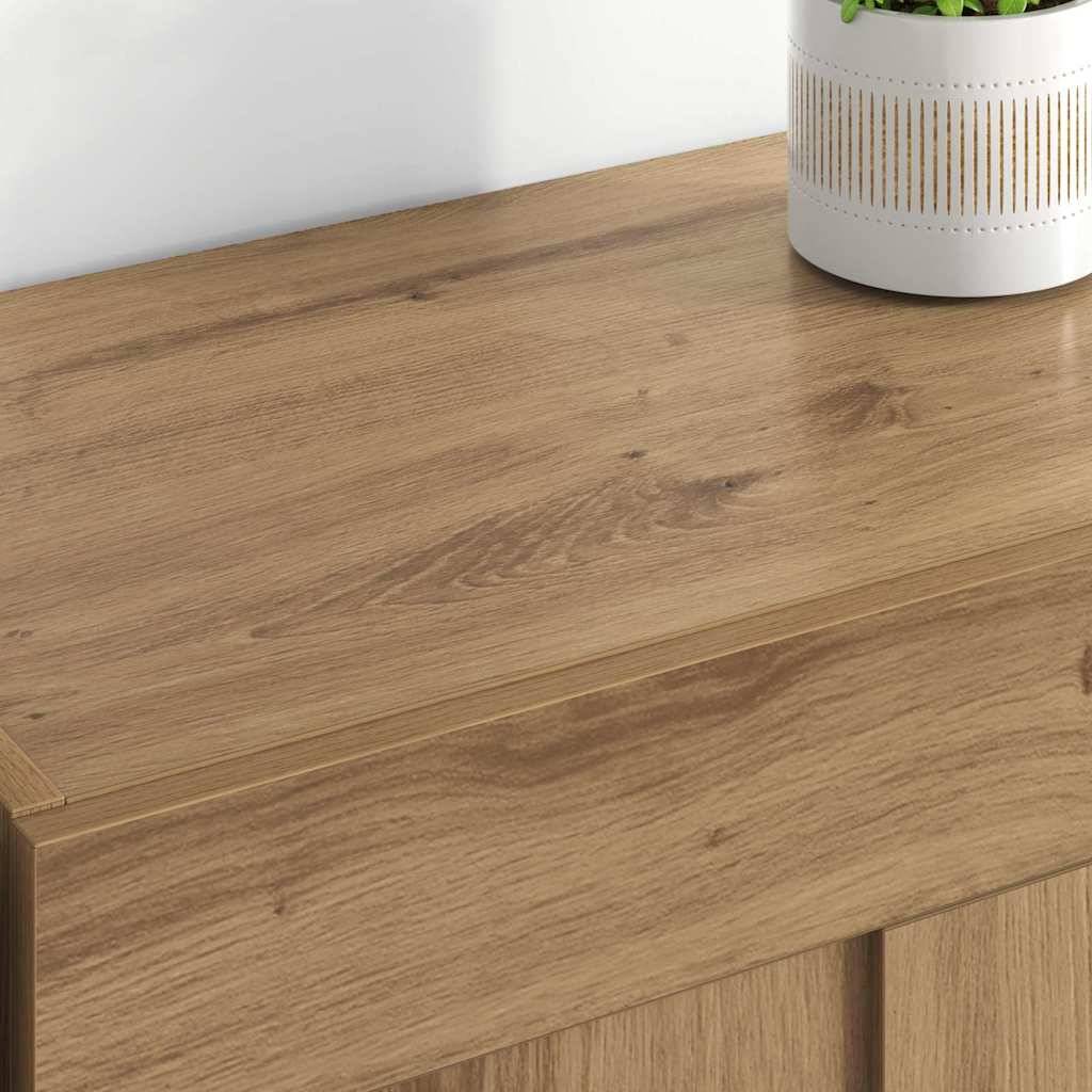 Ein Holztisch mit einem hellbraunen Finish, auf dem rechts ein weißer Topf mit einer grünen, blattreichen Pflanze steht.