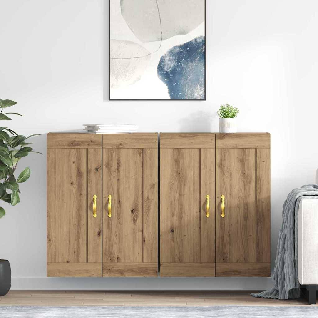 Ein Holzschrank mit vier Türen und goldenen Griffen, oben belegt mit zwei Büchern und einer kleinen Pflanze. Darüber hängt ein abstraktes Gemälde.