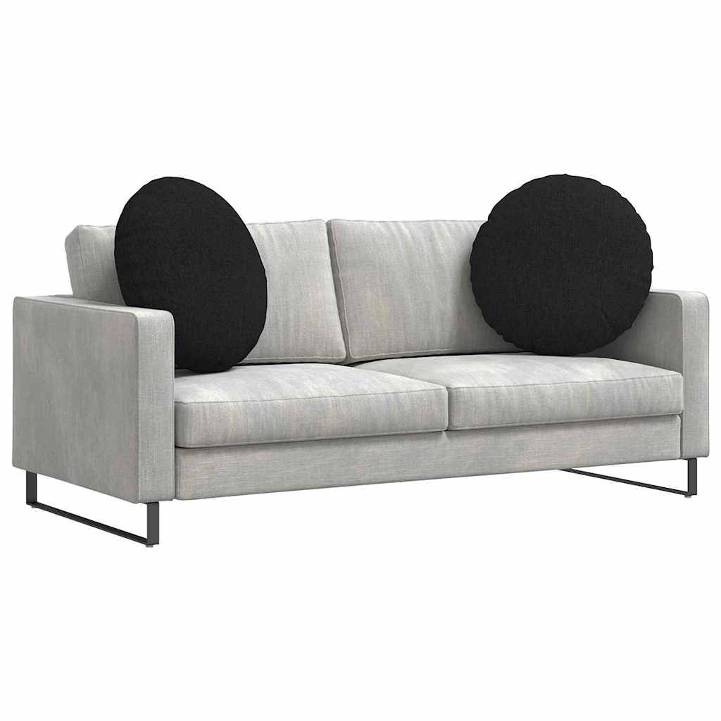 Ein modernes graues Sofa mit Metallfüßen und zwei großen runden schwarzen Kissen an jeder Seite.