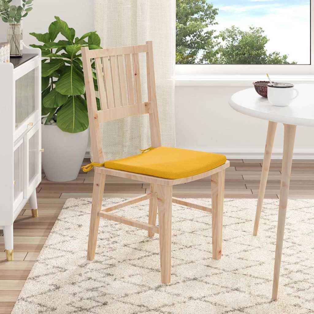 Ein Holzstuhl mit einem gelben Kissen steht neben einem runden weißen Tisch in einem hellen Raum mit einer grünen Pflanze und Fensterblick.