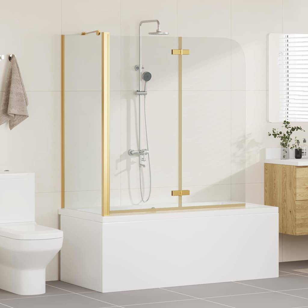 Badezimmer mit weißer Badewanne und Duschkabine mit goldener Einfassung, modernem Toilettenbecken, Holzschrank mit Pflanze und Fliesenboden.