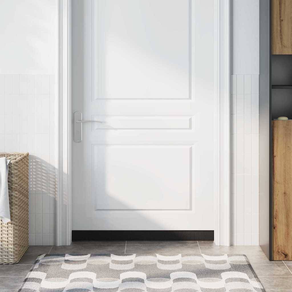 Eine weiße Tür in einem hellen Raum mit einem Weidenkorb links, vor einer gefliesten Wand. Der Boden ist mit einem gemusterten Teppich bedeckt.