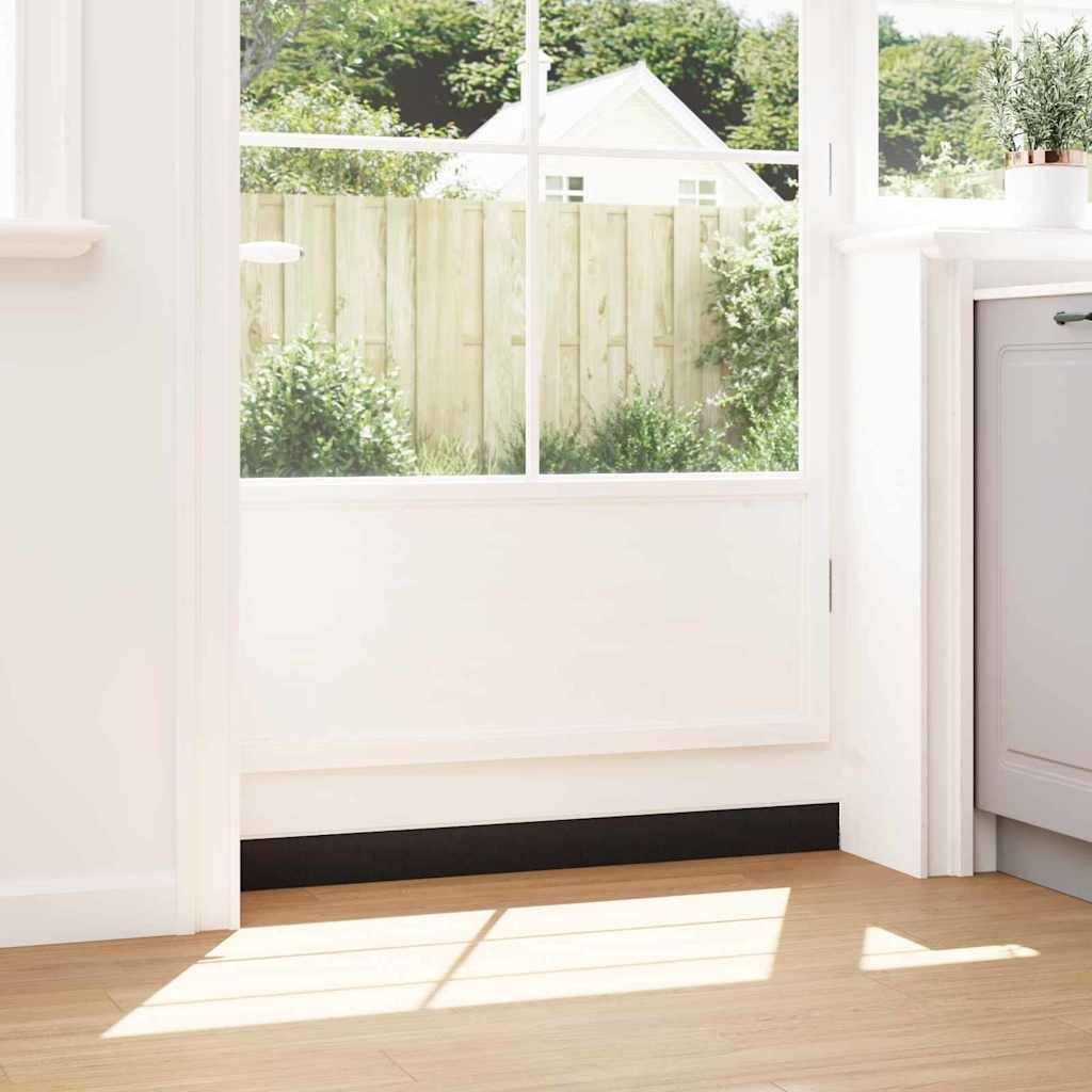 Eine sonnendurchflutete Küchenecke mit Blick aus dem Fenster auf einen Hinterhofgarten. Eine Pflanze steht auf einer grauen Arbeitsplatte neben einem hellen Fenster.