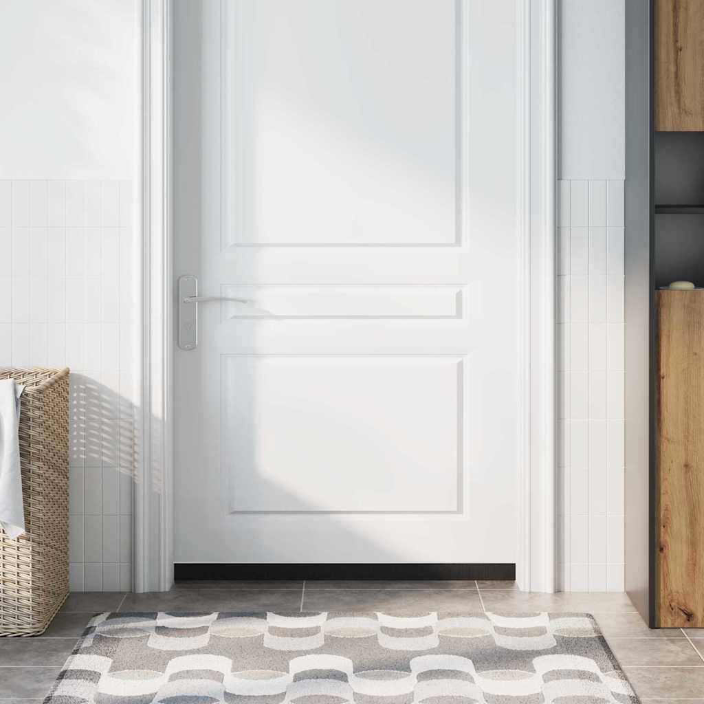 Eine weiße Tür mit Täfelung, umgeben von einer gekachelten Wand, steht leicht angelehnt in einem sonnendurchfluteten Zimmer mit einem gemusterten Teppich und einem Weidenkorb.