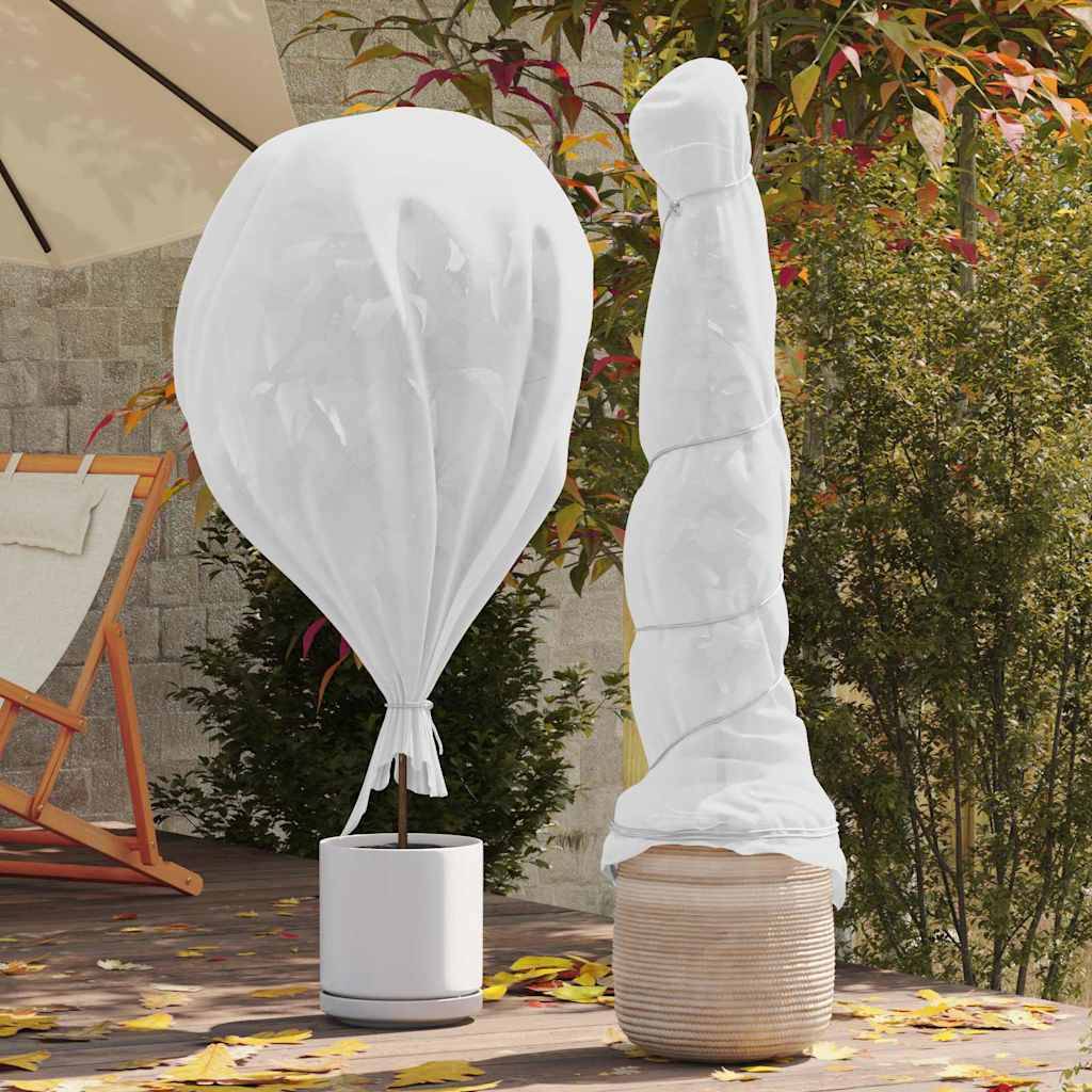 Ein Gartenpatio mit einer großen weißen Ballonskulptur in einem Topf und einem großen, eingewickelten Objekt, umgeben von Herbstlaub und Gartenmöbeln.
