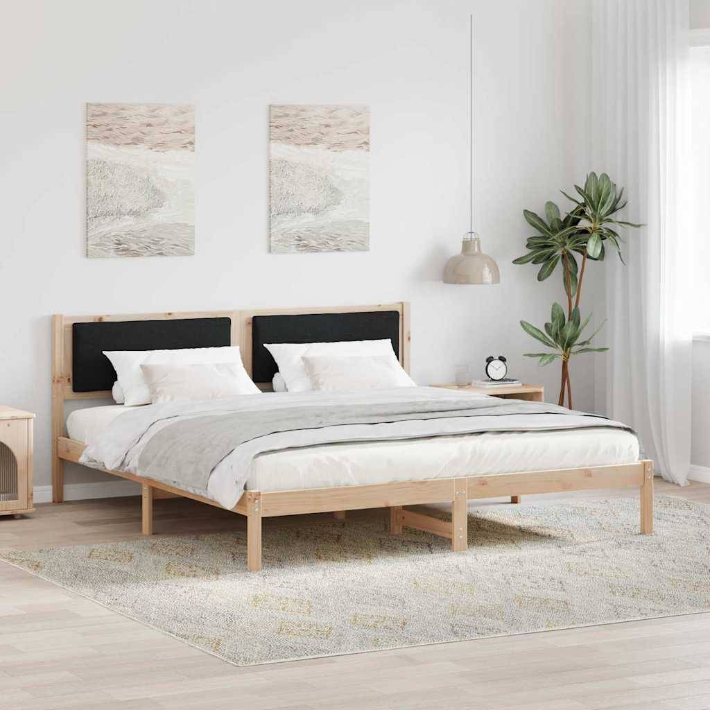 Ein modernes Schlafzimmer mit einem Holzbett, weißer Bettwäsche, zwei Kunstwerken an der Wand, einem Nachttisch, einer Lampe und einer Topfpflanze, alle auf einem hellen Teppich.