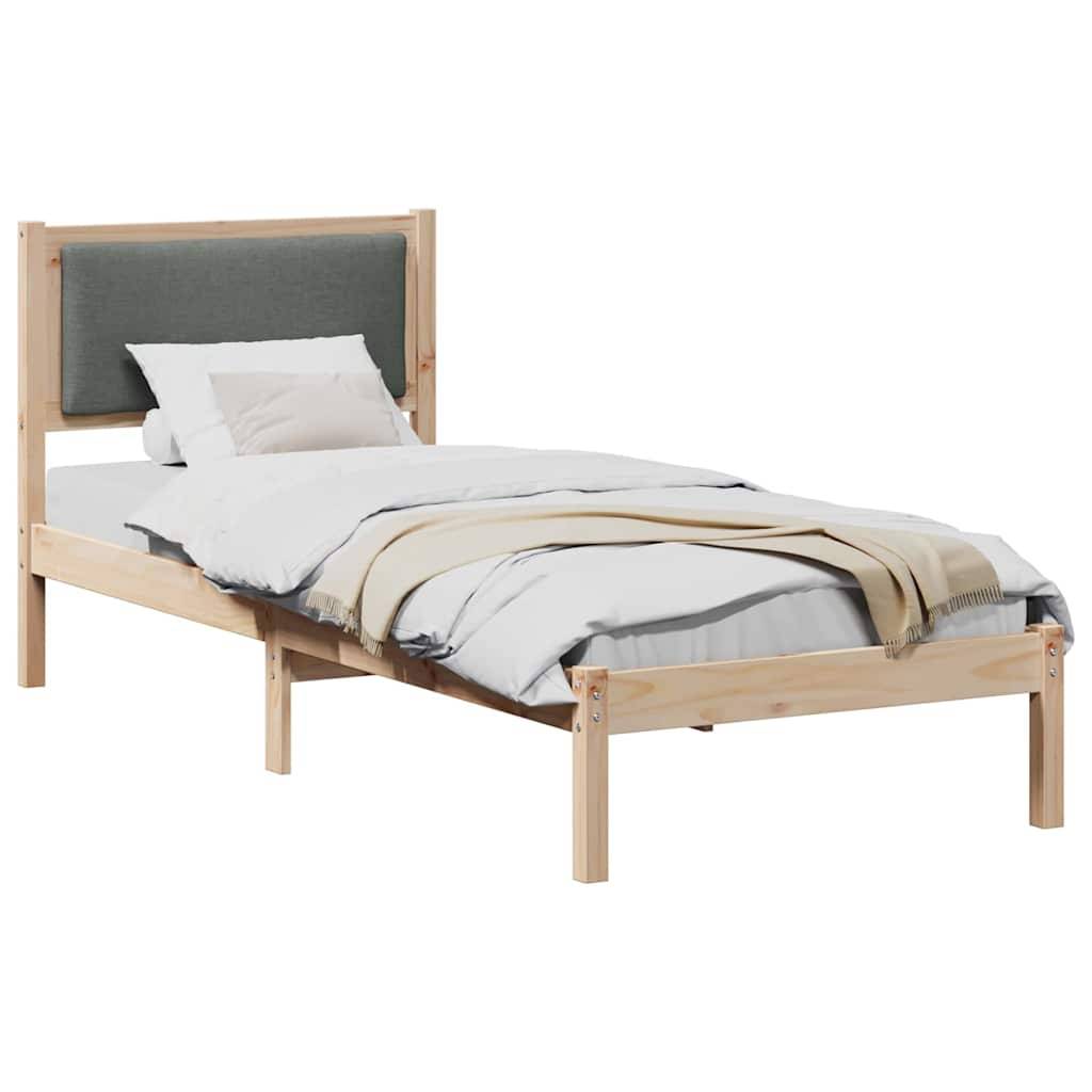 Ein Holzbett in Einzelbettgröße mit einem grau gepolsterten Kopfteil. Es ist ordentlich gemacht mit weißer Bettwäsche und einer beigen Decke.