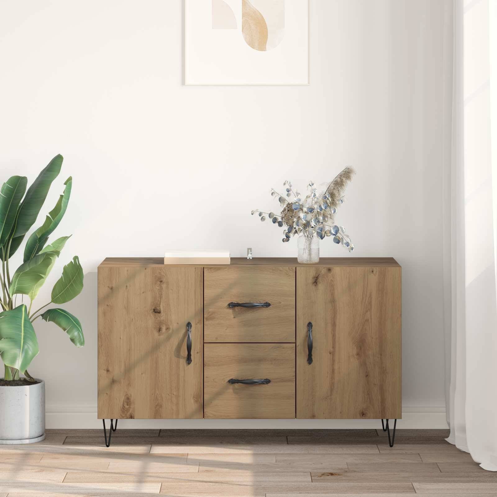 Holzkommode mit zwei Türen und zwei Schubladen an einer weißen Wand, mit einer Topfpflanze und einer Vase oben darauf in einem hellen Raum.