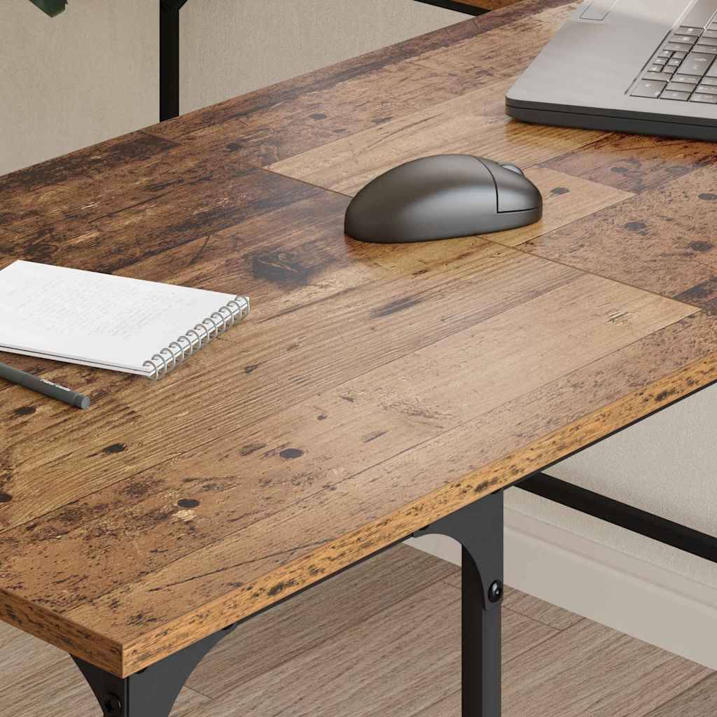 Ein Holzschreibtisch mit einem Notizbuch und einem Stift auf der linken Seite, eine kabellose Maus in der Mitte und ein teilweise sichtbarer Laptop auf der rechten Seite.