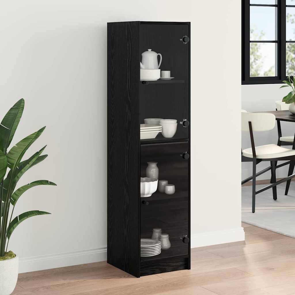Hoher, schwarzer Glastürschrank mit weißem Geschirr und Teekanne auf den Regalen, der an einer hellen Wand steht; Teil des Esszimmerensembles.