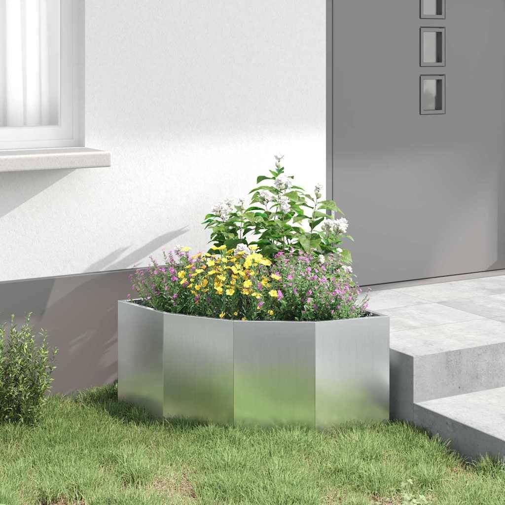 Eine moderne Außengestaltung mit einem Metallpflanzkübel, gefüllt mit lebhaften weißen und gelben Blumen neben einem Steinweg und einer grauen Tür.