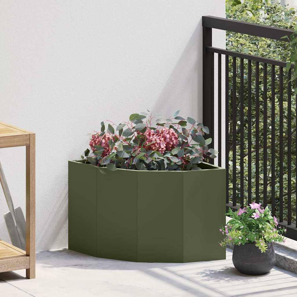 Ein Eckenblumentopf, gefüllt mit rosa Blumen und grünen Blättern, steht auf einem sonnenbeschienenen Balkon neben einem schwarzen Geländer und schafft eine lebendige, natürliche Dekoration.