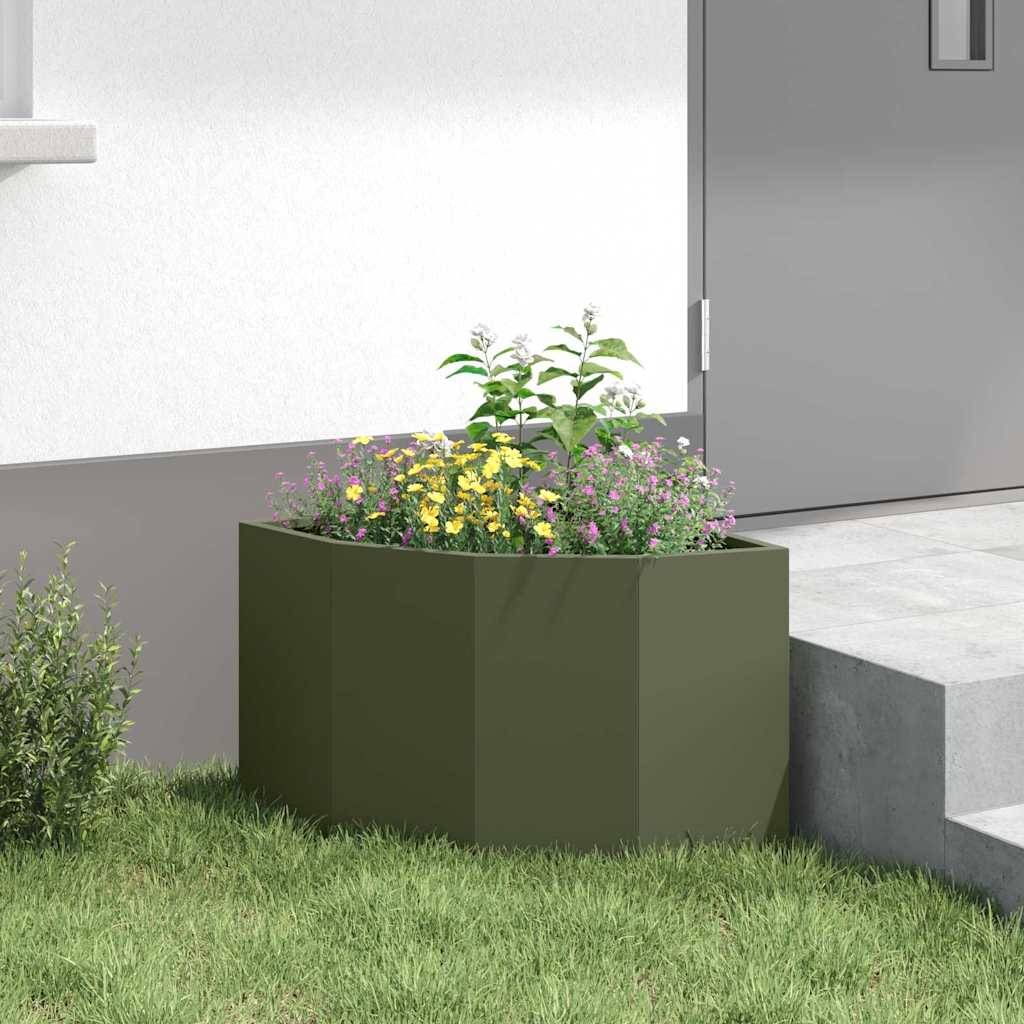 Ein rechteckiger Pflanzkübel mit bunten Blumen steht auf einer Rasenfläche in der Nähe einer weißen Wand und einer grauen Tür.