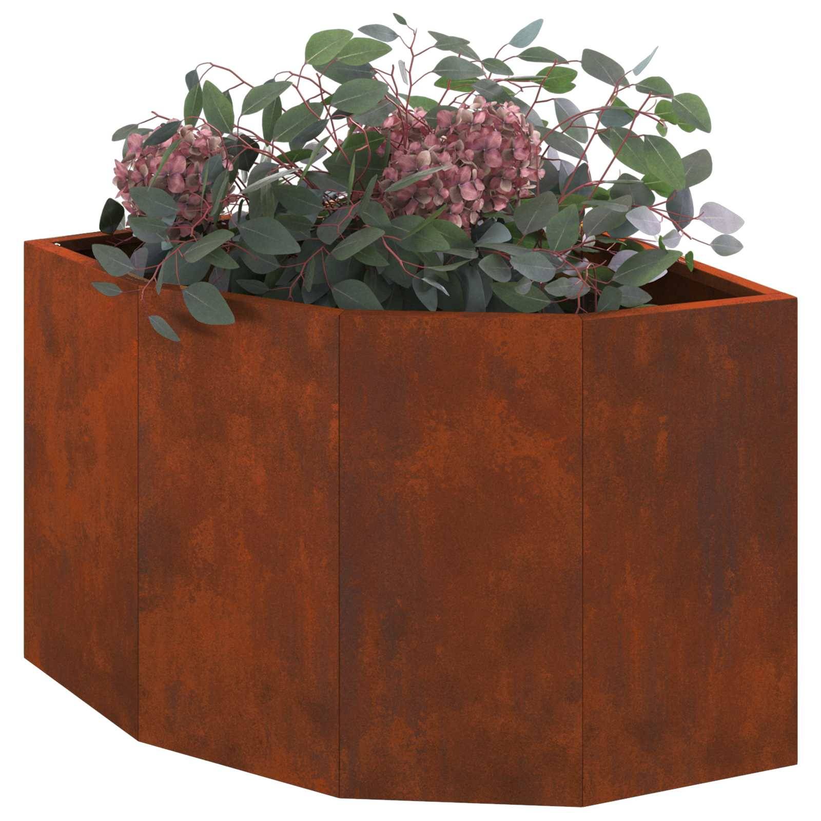 Ein rostfarbener Metallblumenkübel gefüllt mit üppigen grünen Pflanzen und Trauben von rosa Blüten.