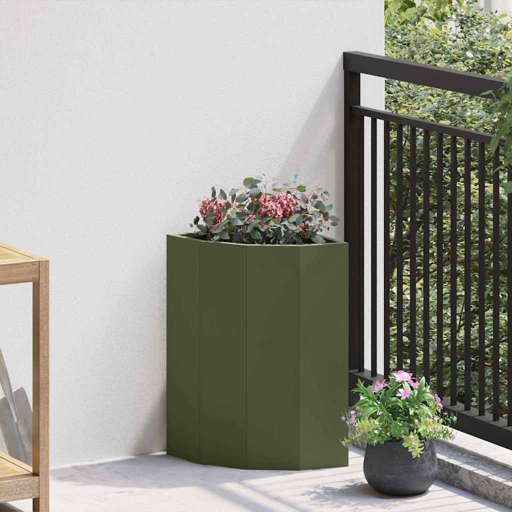 Ein Eckbalkon mit einem kleinen grünen Pflanzkübel beherbergt dekorative rosa und weiße Blumen, gerahmt von einem schwarzen Geländer und einer hellen Wand.