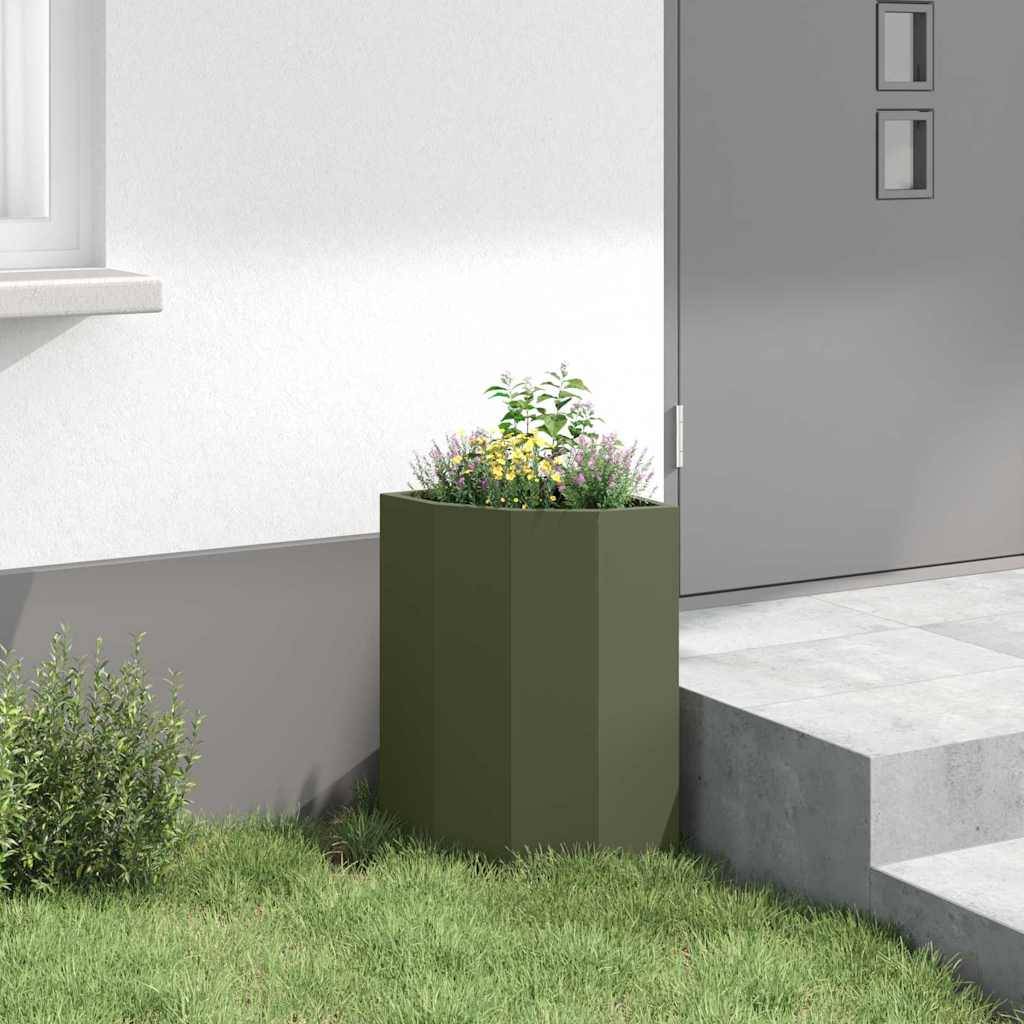 Ein großer grüner Blumentopf mit Blumen steht auf einer Betonterrasse neben einer geschlossenen grauen Tür in einem modernen Außenbereich. Ein kleines Fenster ist oberhalb zu sehen.