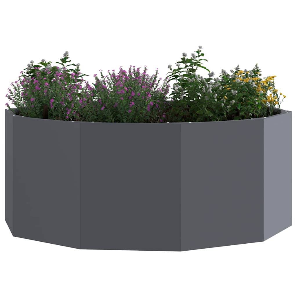 Ein grauer, sechseckiger Pflanzkasten, gefüllt mit verschiedenen bunten Blumen und grünem Blattwerk, der ein einfaches und modernes Gartendesign präsentiert.