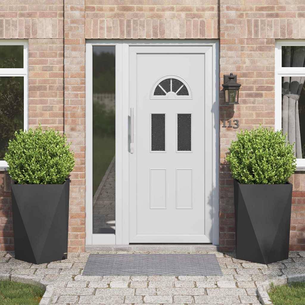 Eine weiße Eingangstür mit dekorativen Glasfenstern, flankiert von großen schwarzen Pflanzgefäßen mit grünen Sträuchern. Hausnummer 113 ist an der Wand.