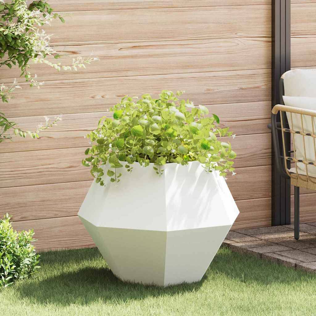 Ein moderner, geometrischer Pflanzenbehälter mit grünen, blattreichen Pflanzen steht auf einer grasbewachsenen Terrasse, mit Holzwandpaneelen im Hintergrund.