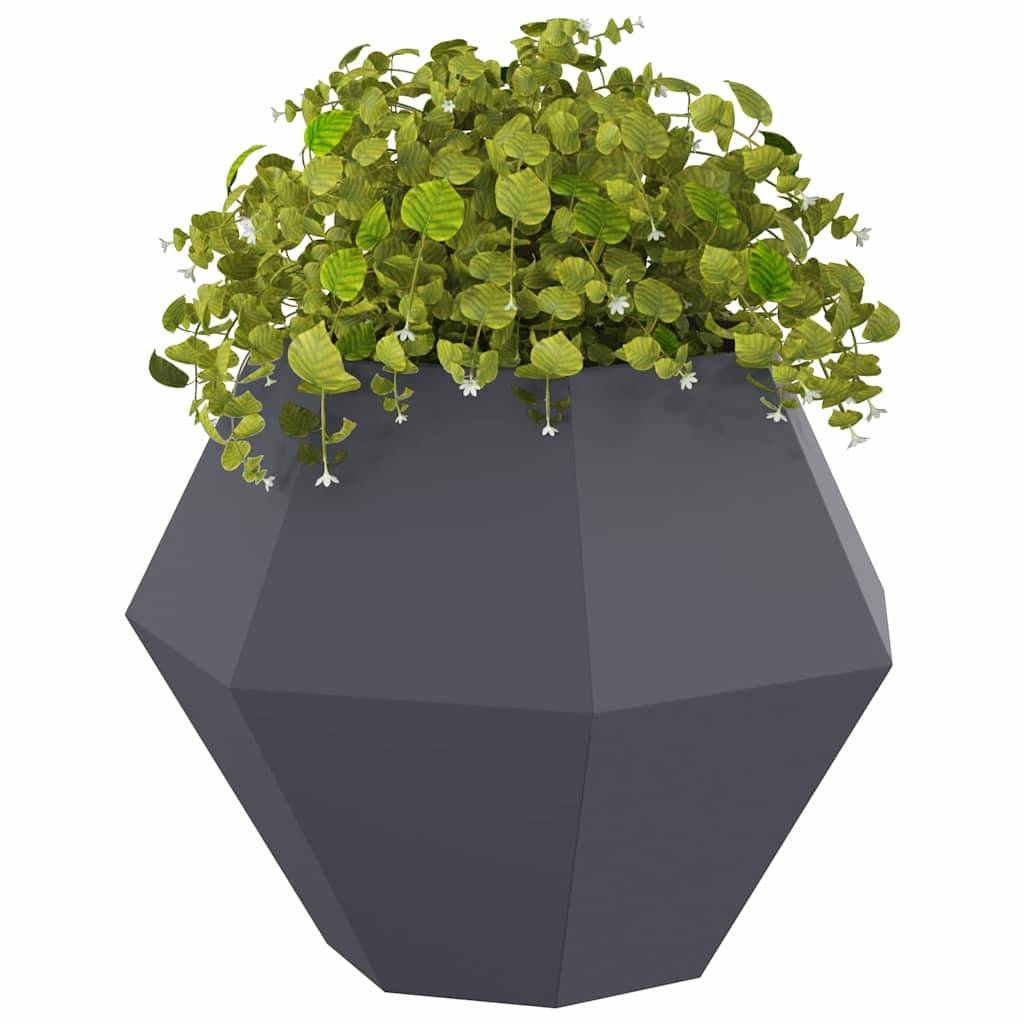 Ein geometrischer, dunkelgrauer Pflanztopf mit üppigem grünem Blattwerk, das über den Rand fällt und kleine weiße Blüten aufweist.