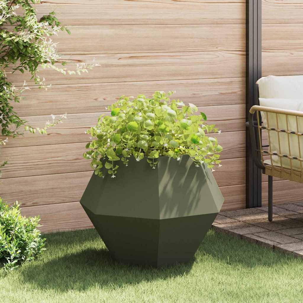 Ein geometrischer Pflanzkübel, gefüllt mit grünen Pflanzen, steht auf einem Rasengrundstück in der Nähe eines Holzzauns und eines gepolsterten Gartenstuhls.