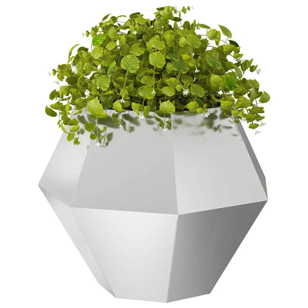 Ein geometrischer, facettierter weißer Pflanzentopf, der eine üppige grüne Pflanze mit kleinen, runden Blättern enthält.