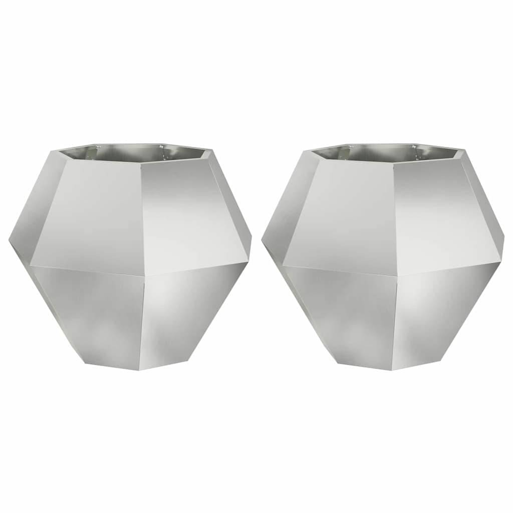 Silberne, facettierte geometrische Kerzenhalter, einer links und einer rechts, reflektieren das Licht und deuten auf eine moderne minimalistische Einrichtung hin.