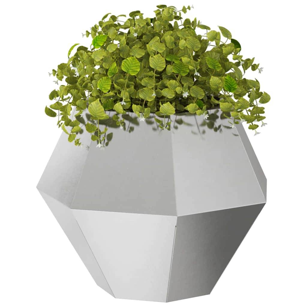 Ein geometrischer, facettierter grauer Pflanzentopf beherbergt eine üppige grüne Pflanze mit kleinen, runden Blättern und wirft weiche Schatten auf dessen Oberfläche.