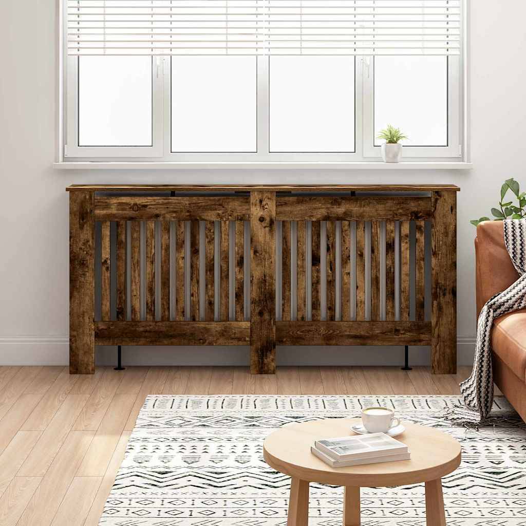 Ein gemütliches Wohnzimmer zeigt eine Holzheizungsverkleidung, einen runden Tisch mit einem Buch und einer Tasse, einen gemusterten Teppich und ein Fenster mit einer kleinen Pflanze.