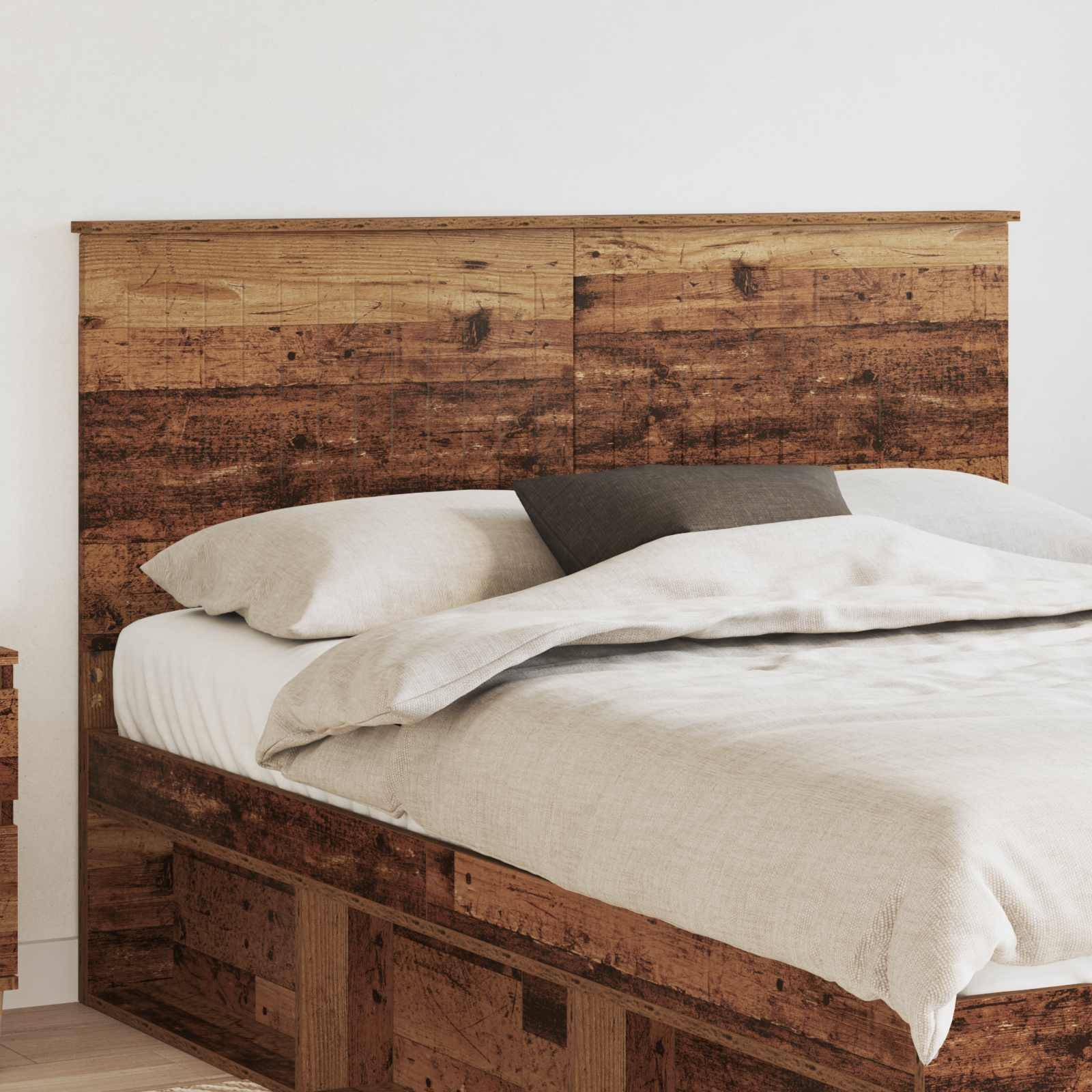 Ein Holzbett mit weißer Bettwäsche und einem grauen Kissen in einer minimalistischen Raumgestaltung.