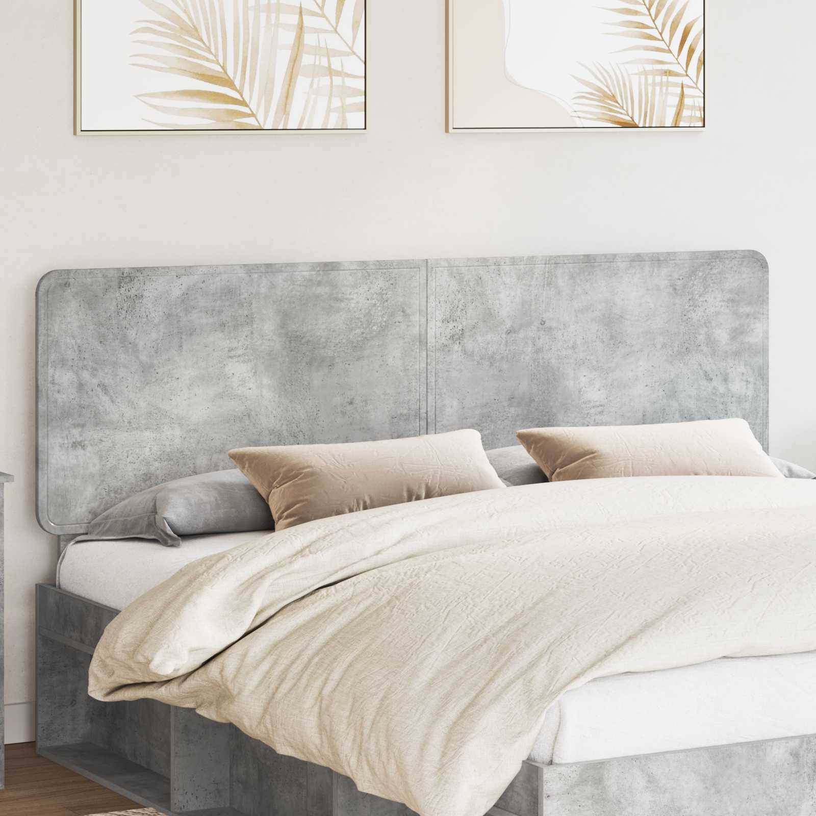 Ein modernes Schlafzimmer mit einem grauen gepolsterten Kopfteil, beigefarbener Bettwäsche, zwei beigefarbenen Kissen und zwei minimalistische botanische Kunstwerke an der Wand.
