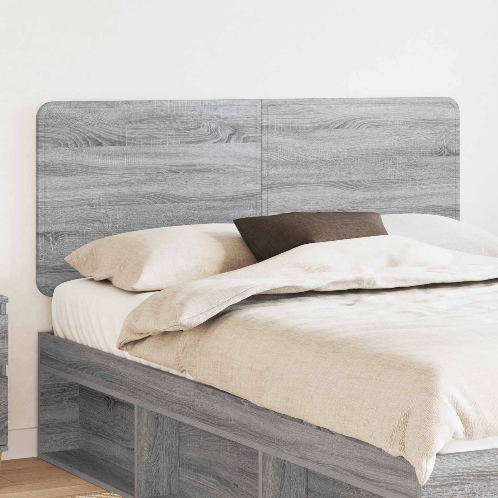Ein modernes graues Holzbett mit beigefarbener Bettwäsche und schwarzem Kissen in einer minimalistischen Raumgestaltung. Das Kopfteil und die Nachttische passen zum Bett.