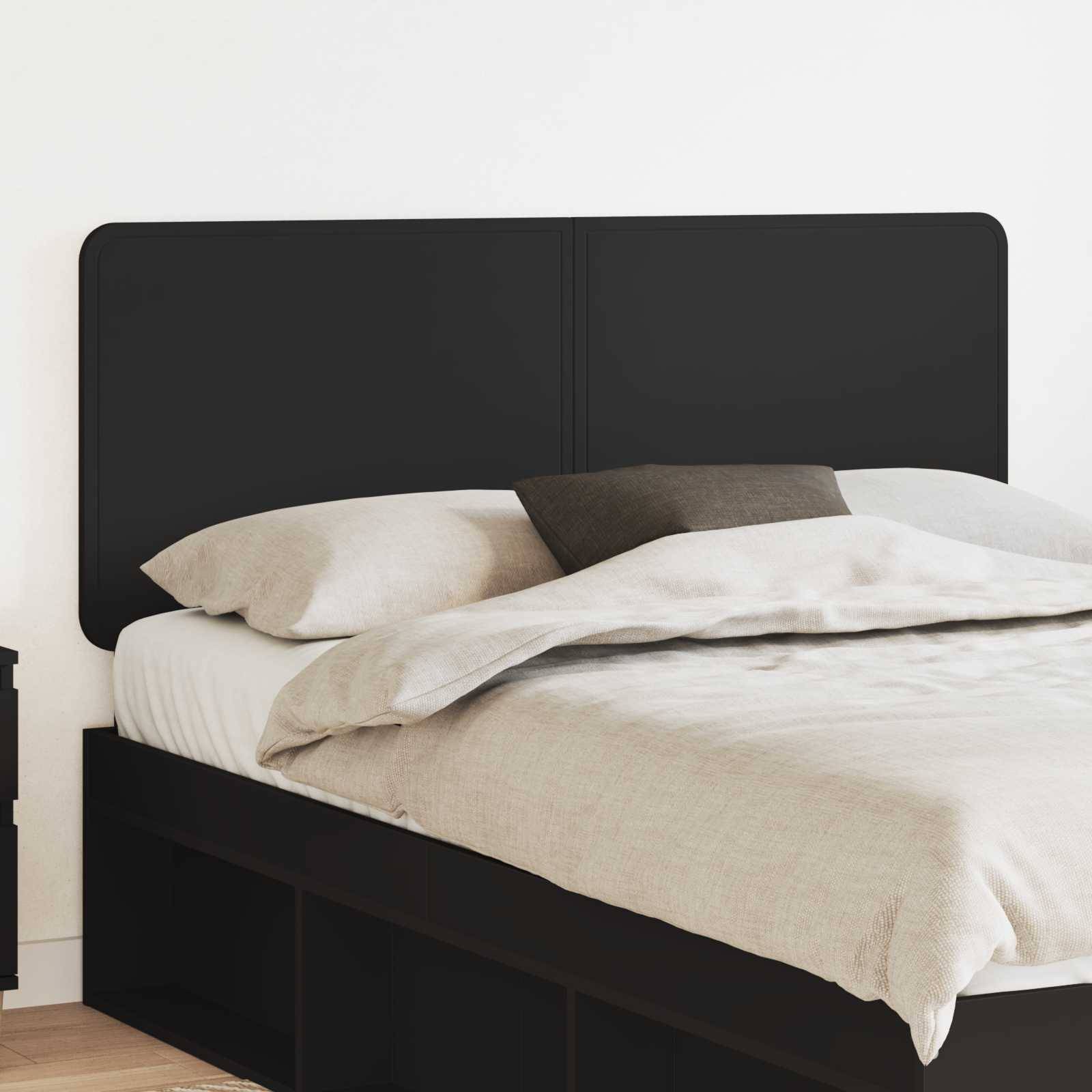 Ein minimalistisches Schlafzimmer mit einem großen Bett, das ein schwarzes Kopfende, weiße Laken und ein graues Kissen hat. Ein Nachttisch steht auf der linken Seite.